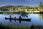 Family paddling in Manzanita Lake in homemade wooden kayak, Lassen Volcanic National Park, California